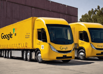 Two bright yellow Google and J.B. Hunt transport trucks parked in front of shipping containers. The trucks showcase a strategic partnership advancing transportation innovation. - Supply Chain News