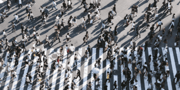 Busy city crosswalk with many pedestrians. Humans navigating a modern urban environment. - Supply Chain News