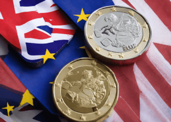 Post-Brexit UK-EU Trade Deal displayed through Eu and British coins on a flag.