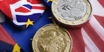 Post-Brexit UK-EU Trade Deal displayed through Eu and British coins on a flag.