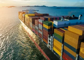 Container ship carrying cargo at sea during sunset. Illustrates global trade and recent export/import declines. - Supply Chain News