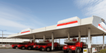 A red truck parked in front of a Chevron gas station.