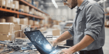 Warehouse worker using laptop to manage supply chain, enhancing logistics with digital technology. - Supply Chain News