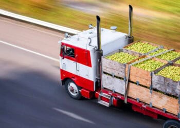 Red truck carrying crates of green apples, illustrating global food export challenges one year after the Ukraine invasion. - Supply Chain News