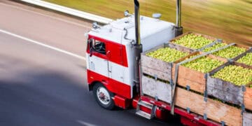 Red truck carrying crates of green apples, illustrating global food export challenges one year after the Ukraine invasion. - Supply Chain News