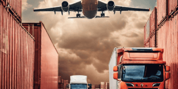 A plane is flying over a truck and containers, representing the challenges faced in supply chain management during the pandemic.
