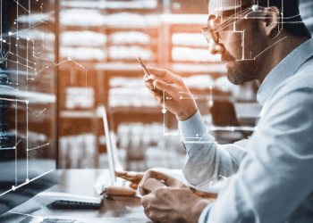 Man reviewing data on laptop, improving supply chain analytics through data quality. - Supply Chain News