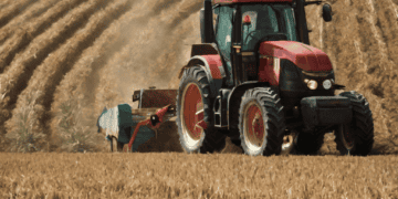 A government-aided tractor assisting farmers in the field.