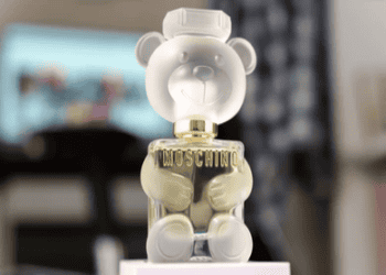 Exploring the future with a Moschino perfume bottle adorned with a cute teddy bear on top.
