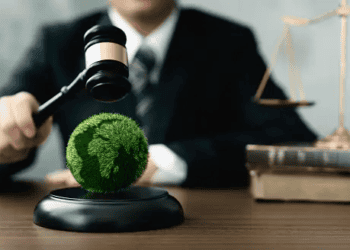 Gavel striking a globe covered in green grass, symbolizing environmental justice. - Supply Chain News