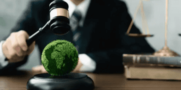 Gavel striking a globe covered in green grass, symbolizing environmental justice. - Supply Chain News