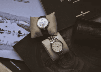 Two rare Geneva watches sitting on top of a book.