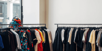 Modern clothing boutique interior with racks of apparel and accessories. Luxury goods displayed for sale. - Supply Chain News