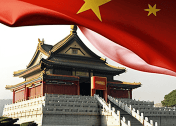 A Chinese flag is flying in front of a building in China.