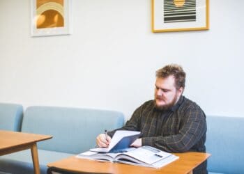 Man reviewing documents at a table, researching export controls on germanium and gallium. - Supply Chain News