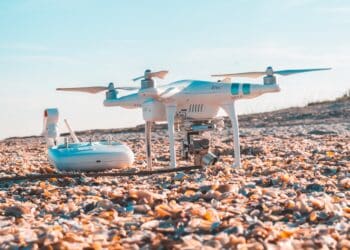 Drone and remote control on a shell-covered beach. - Supply Chain News