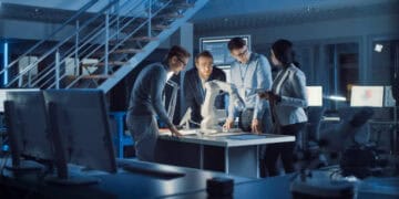 Team of engineers collaborating on robotics project, showcasing AI integration and investment in robotics startups. - Supply Chain News