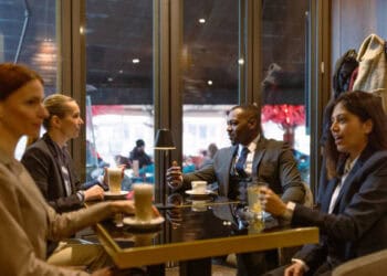 Businesspeople collaborate around a table, discussing sustainable soy supply chains using blockchain technology. - Supply Chain News