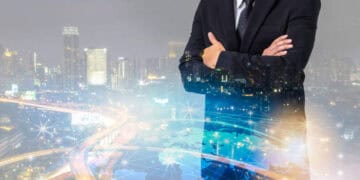 Confident businessman with arms crossed, superimposed over a global network and cityscape, illustrating fintech's impact on global trade. - Supply Chain News