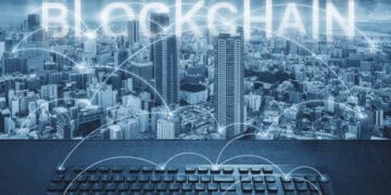 Hands typing on keyboard, "Blockchain" displayed over city skyline. Addressing supply chain disruptions. - Supply Chain News
