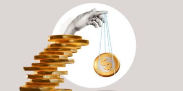 Hand balancing stack of gold coins and a single coin on a string; illustrating supply chain resilience and cost-effectiveness. - Supply Chain News