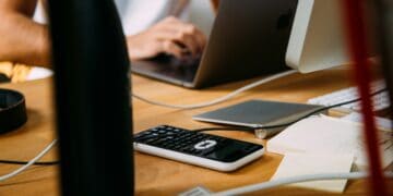 Person working on laptop, calculator, and notes; de-banking concerns. - Supply Chain News