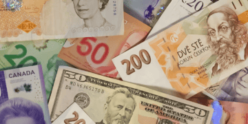 Assorted banknotes from various countries, including US dollars, Canadian dollars, British pounds, and Czech koruna, illustrating the currency impact on luxury goods prices. - Supply Chain News