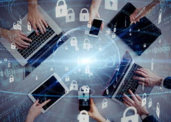 Multiple hands using laptops, tablets, and smartphones, illustrating global cybersecurity and technological growth. - Supply Chain News