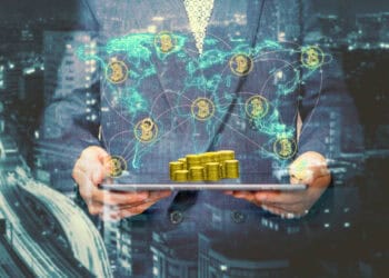 Businessperson holding tablet displaying bitcoin stacks and global network. Bitcoin price surge. - Supply Chain News