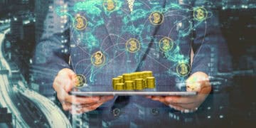 Businessperson holding tablet displaying bitcoin stacks and global network. Bitcoin price surge. - Supply Chain News