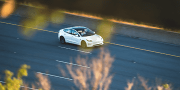 White Tesla Model 3 driving on highway. - Supply Chain News