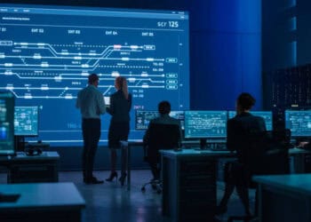 Control room with multiple computer screens displaying complex data flow charts related to US chip export controls impacting China. - Supply Chain News