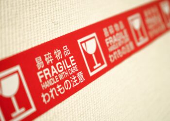 A red and white label highlighting supplier risks on a wall.