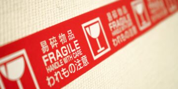 A red and white label highlighting supplier risks on a wall.