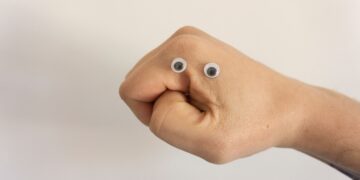Close-up of a fist with googly eyes, suggesting a frustrated or angry face. - Supply Chain News