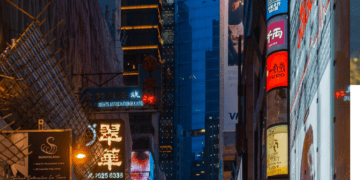 Vibrant Hong Kong street at night, showcasing luxury brand signage and bustling crowds. Sasa and other shops are visible. - Supply Chain News