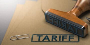 Wooden stamp reading "Tariff" on kraft paper; potential tariffs on US whiskey imports to Europe. - Supply Chain News