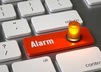 Red "Alarm" button on keyboard with flashing light; data security incident. - Supply Chain News