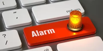 Red "Alarm" button on keyboard with flashing light; data security incident. - Supply Chain News