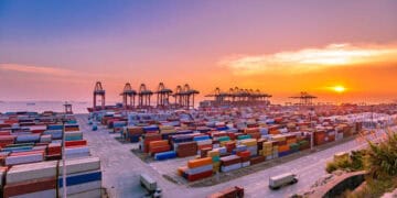A view of a container port at sunset, showcasing the bustling trade between China and the rest of the world through imports and export growth.