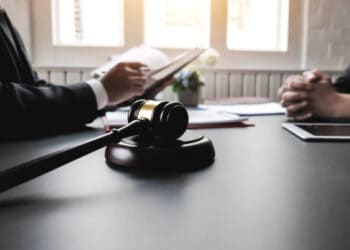 Lawyers meeting at table, gavel in foreground. Financial crime prevention. - Supply Chain News