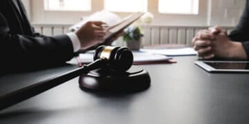 Lawyers meeting at table, gavel in foreground. Financial crime prevention. - Supply Chain News