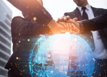 Businesspeople join hands over a digital globe, symbolizing global trade and potential tariff impacts on consumer prices. - Supply Chain News