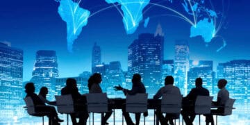 Business people from Bangladesh sitting around a table with a comprehensive overview of global development displayed on a world map.