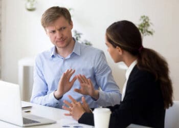 Two businesspeople in discussion, one appearing frustrated. FTX trial. - Supply Chain News