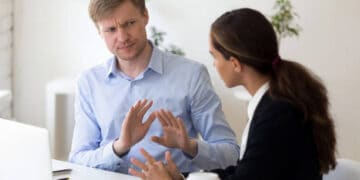 Two businesspeople in discussion, one appearing frustrated. FTX trial. - Supply Chain News