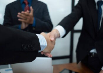 Businesspeople shaking hands, signifying a China-South Korea free trade agreement. - Supply Chain News