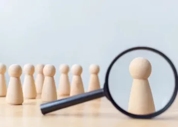 A Privacy-Centric Landscape with a magnifying glass over a group of wooden figures.