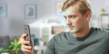 Man using facial recognition on smartphone to combat SIM card fraud in India. - Supply Chain News