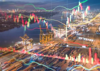 Night view of a busy port with cargo containers and cranes, overlaid with stock market graphs showing India's metal export trends. - Supply Chain News